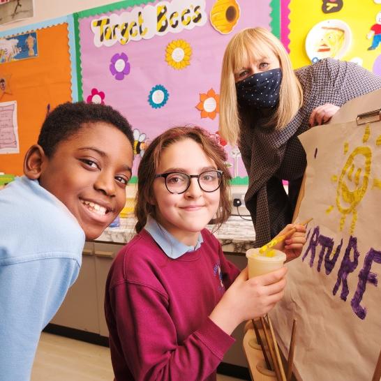 Children with the education minister in NI holding a drawing captioned 'future'